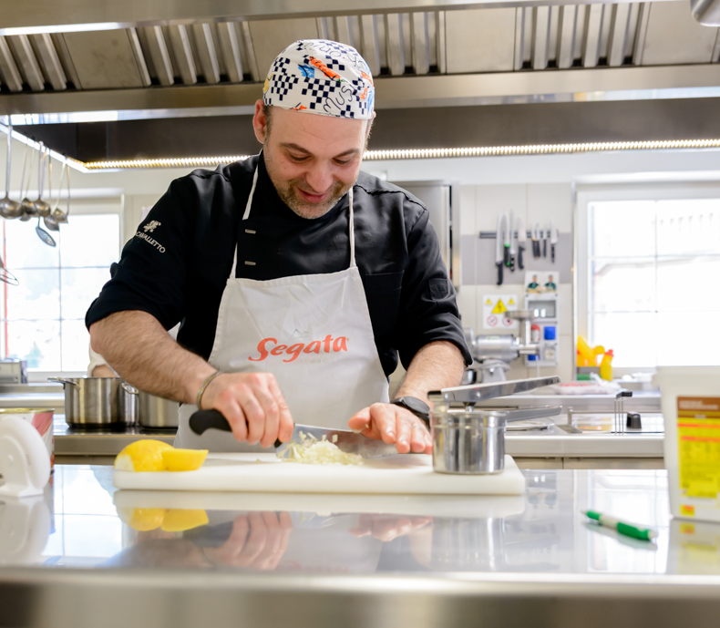 fotografo hotel - cuoco al lavoro in cucina luminosa